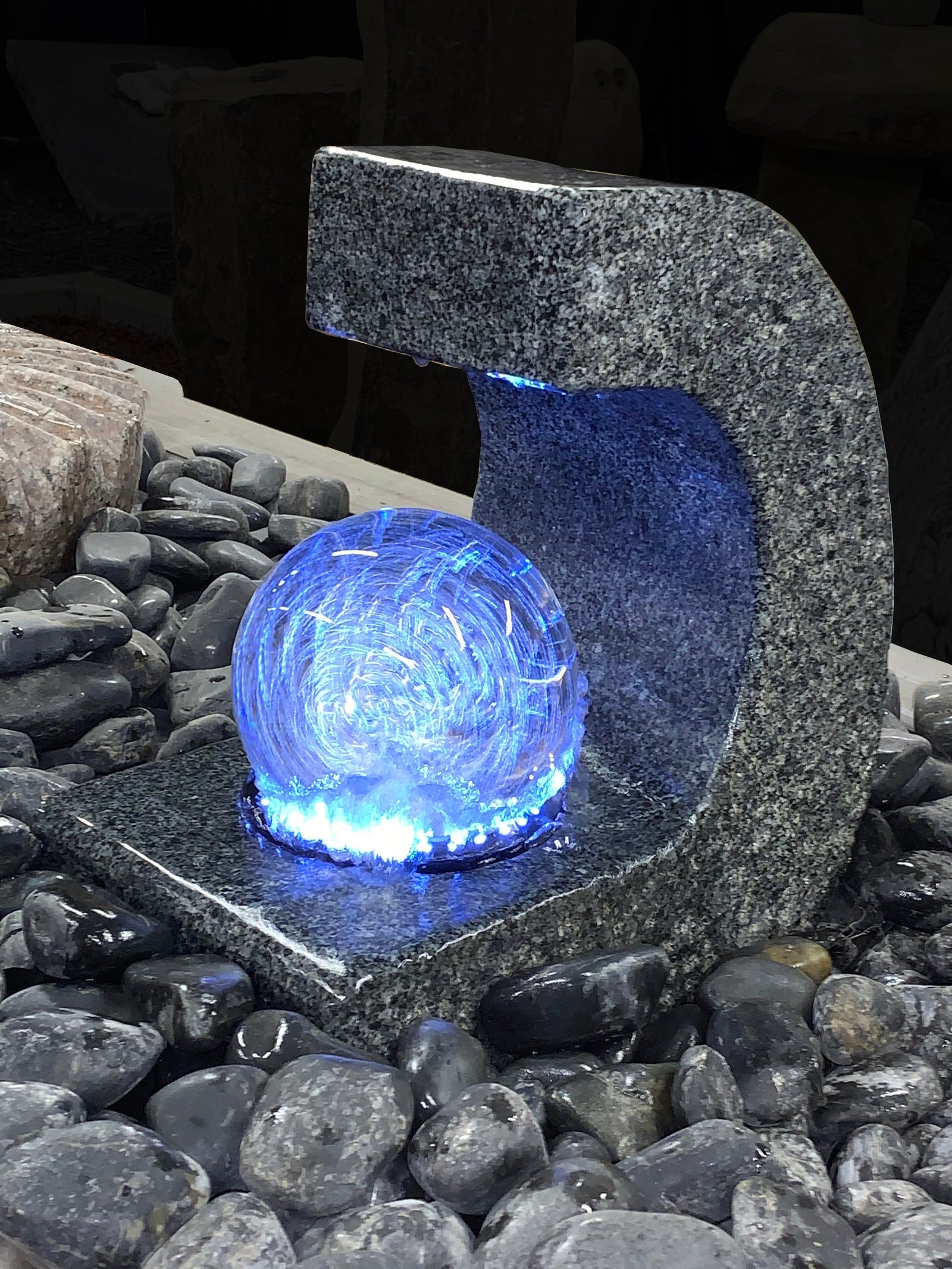 Granite rolling ball fountain with LED light in a C-shaped design.