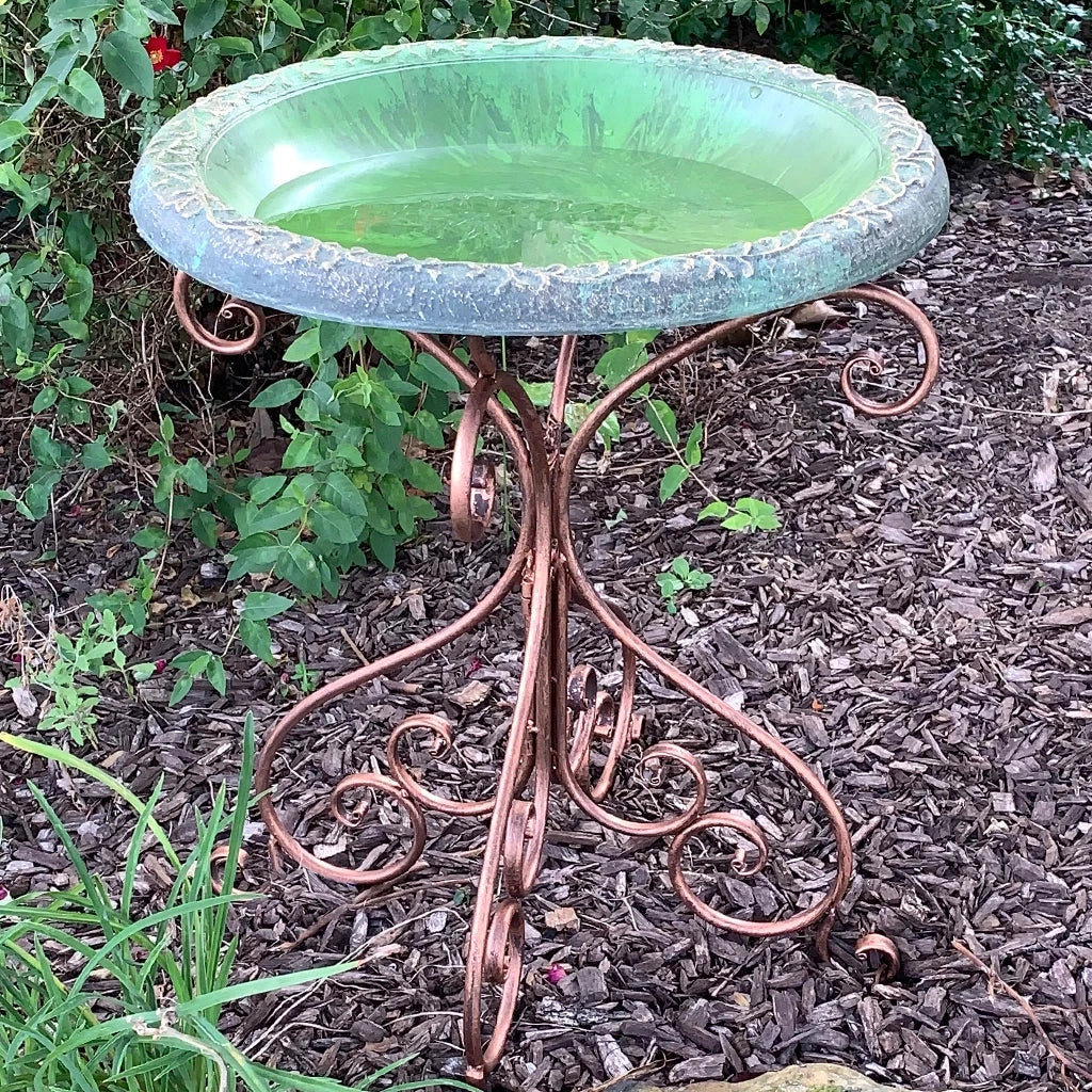Very decorative and practical fiber clay birdbath top on a scrolling antique bronze metal stand.