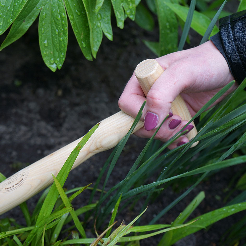 Older hand grapping a P-grip or T-handle gardening tool demonstrating that they require less strength and dexterity to use.