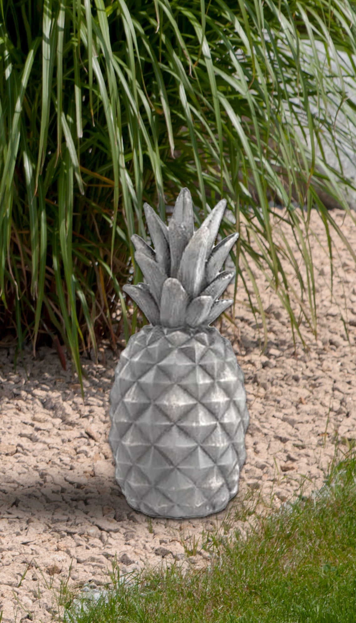 24-inch granite pineapple garden decoration on a gravel path.