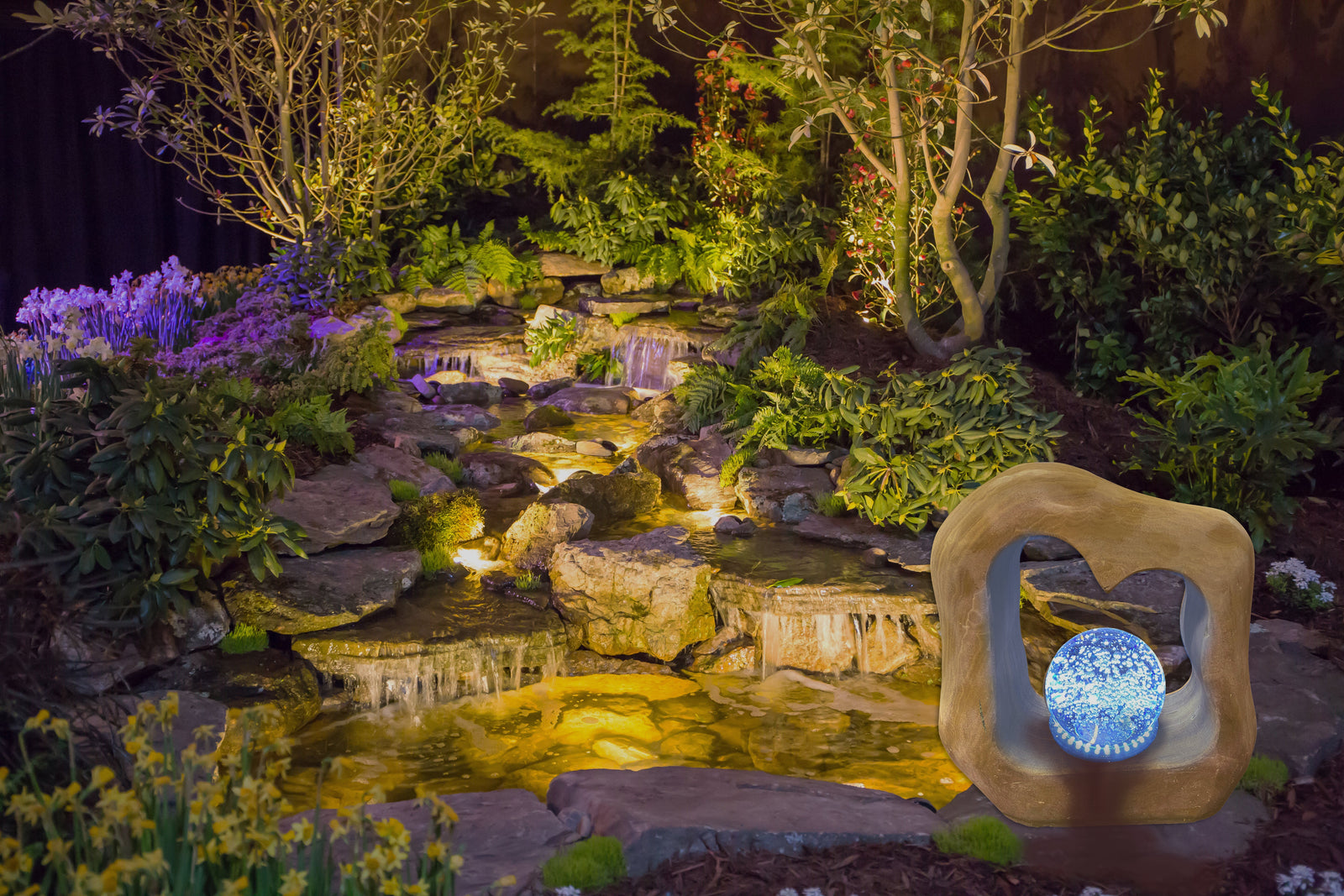 Rolling Ball Marble Fountain Kit with LED light in a garden setting.
