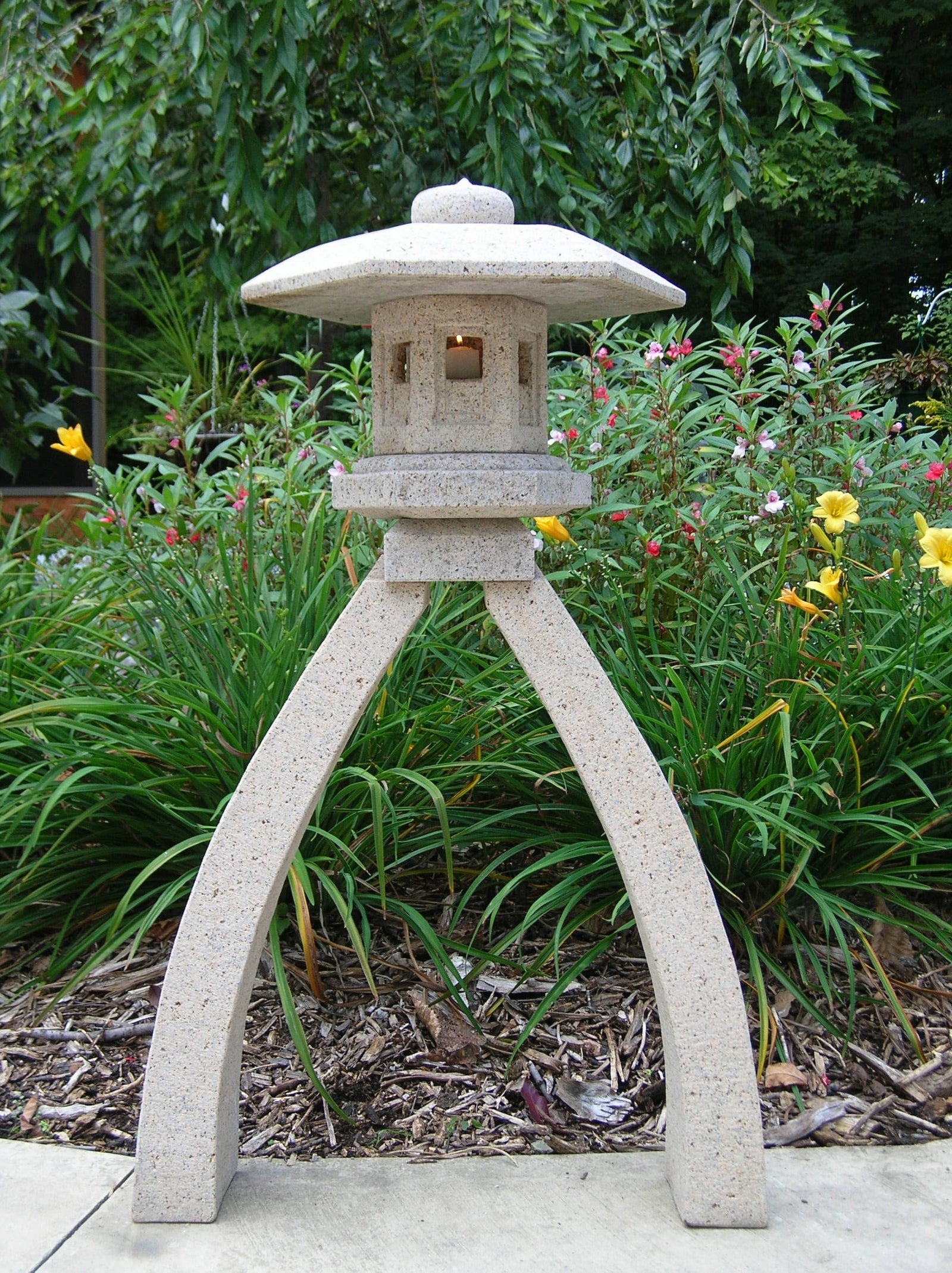 41" H Kotoji Granite Lantern in garden setting with flowers and foliage.